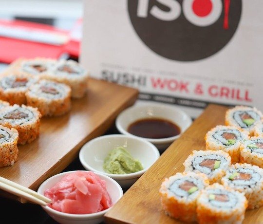 Selection of sushi placed on wooden boards complete with sauce and accompaniments