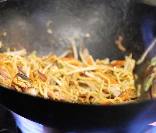 Wok filled with noodles and vegetables